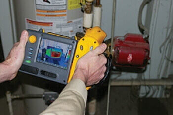 Technician using thermal imaging equipment during preventive maintenance services
